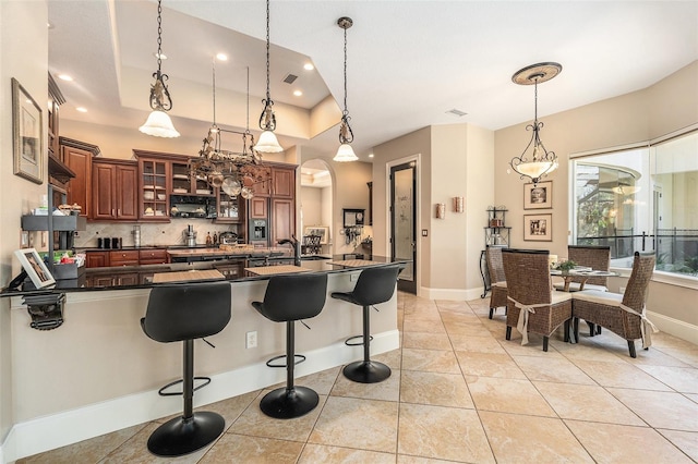 3607 Berger Rd, Lutz, FL 33548 - kitchen featuring dark countertops, decorative light fixtures, a kitchen bar, tasteful backsplash, and recessed lighting