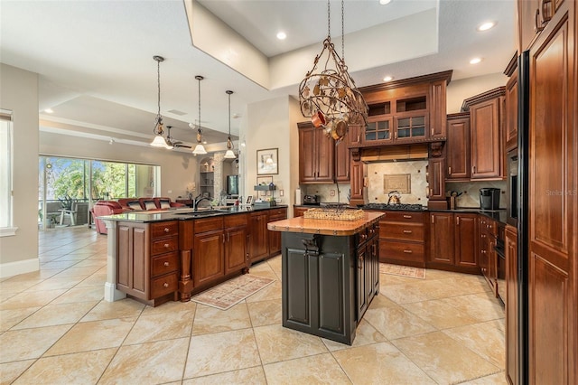 3607 Berger Rd, Lutz, FL 33548 - kitchen with a tray ceiling, backsplash, a kitchen island, decorative light fixtures, and light tile patterned floors