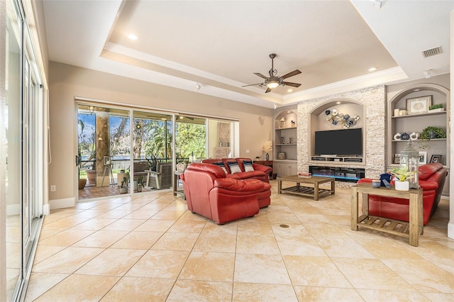 3607 Berger Rd, Lutz, FL 33548 - living room featuring a tray ceiling, built in shelves, a ceiling fan, light tile patterned flooring, and ornamental molding