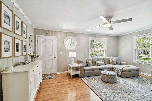 living area featuring a ceiling fan, baseboards, light wood-style floors, ornamental molding, and recessed lighting