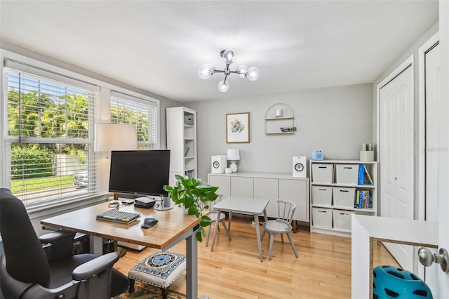 home office featuring a notable chandelier and light wood-style floors