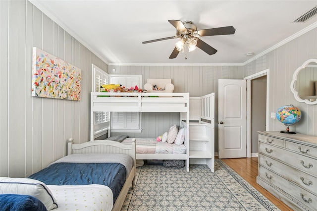 bedroom featuring visible vents, crown molding, wood finished floors, and a ceiling fan