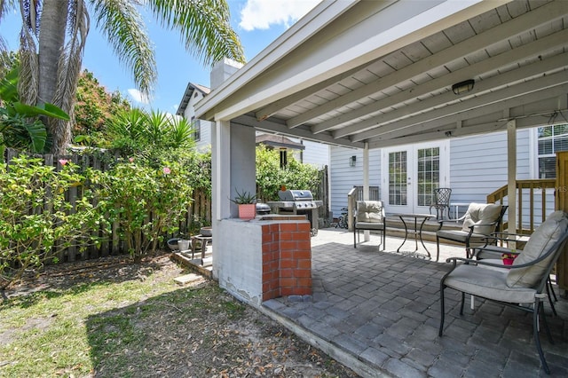 view of patio with a grill, fence, and french doors