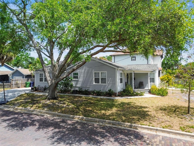 view of front of property featuring fence, a front yard, and a porch