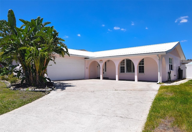 ranch-style house featuring a porch, an attached garage, driveway, and stucco siding
