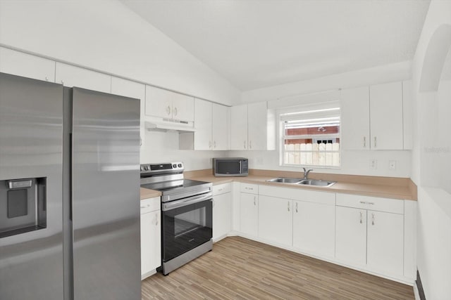 kitchen featuring light countertops, stainless steel appliances, under cabinet range hood, lofted ceiling, and a sink