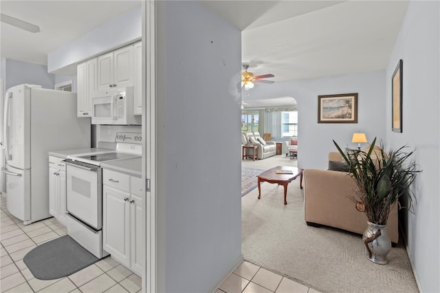 733 Ojai Ave, Sun City Center, FL 33573 - kitchen featuring white appliances, light tile patterned floors, white cabinets, and ceiling fan