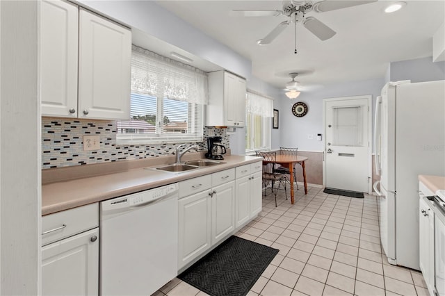 733 Ojai Ave, Sun City Center, FL 33573 - kitchen with a ceiling fan, white dishwasher, light countertops, decorative backsplash, and white cabinetry