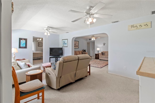 733 Ojai Ave, Sun City Center, FL 33573 - living room featuring arched walkways, a ceiling fan, light carpet, and a textured ceiling
