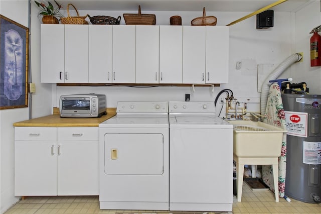 733 Ojai Ave, Sun City Center, FL 33573 - laundry room featuring washer and dryer, cabinet space, water heater, and light flooring