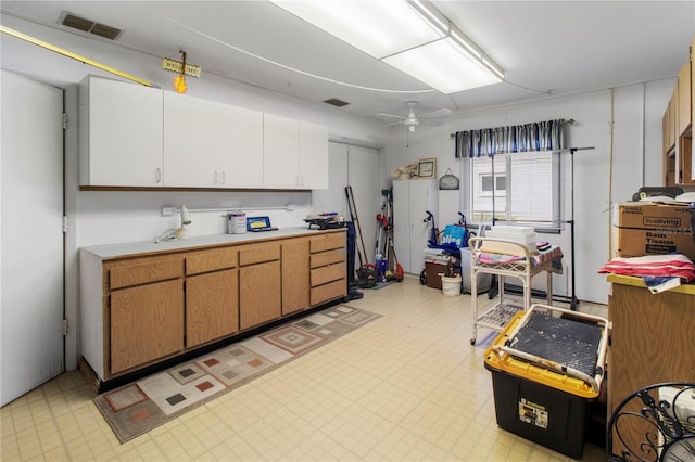 733 Ojai Ave, Sun City Center, FL 33573 - kitchen featuring light countertops, light flooring, ceiling fan, and white cabinets