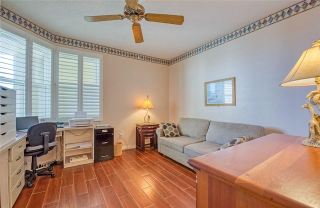 office space with wood finished floors, a wealth of natural light, a ceiling fan, and baseboards