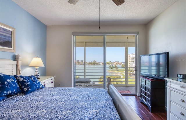 bedroom featuring dark wood finished floors, a textured ceiling, and access to outside
