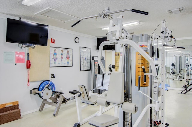 workout area featuring crown molding, a textured ceiling, and visible vents