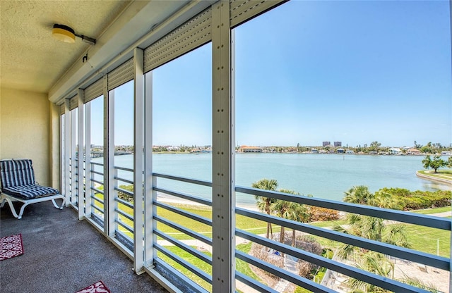 7872 Sailboat Key Blvd S Unit 404, South Pasadena, FL 33707 - sunroom / solarium with a water view, a textured ceiling, and carpet
