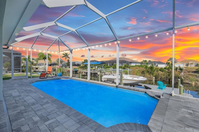 1817 SW 29th Ter, Cape Coral, FL 33914 - pool at dusk featuring an outdoor pool, boat lift, a dock, and a patio area