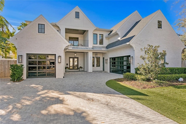 1903 S Cardenas Ave, Tampa, FL 33629 - rear view of house featuring a balcony, decorative driveway, french doors, brick siding, and an attached garage