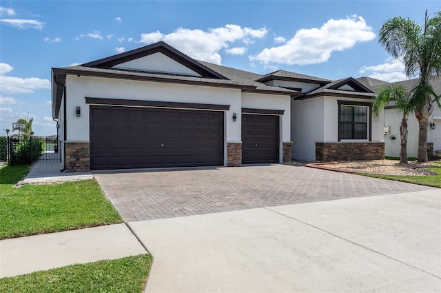 10008 Celtic Ash Dr, Ruskin, FL 33573 - view of front of home featuring stone siding, stucco siding, and decorative driveway