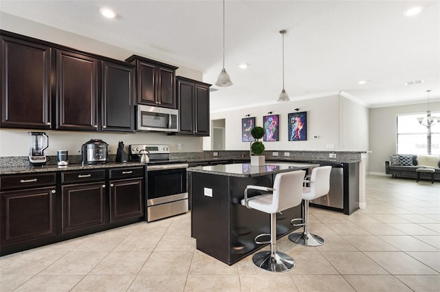 10008 Celtic Ash Dr, Ruskin, FL 33573 - kitchen featuring appliances with stainless steel finishes, a kitchen breakfast bar, ornamental molding, light tile patterned flooring, and a peninsula
