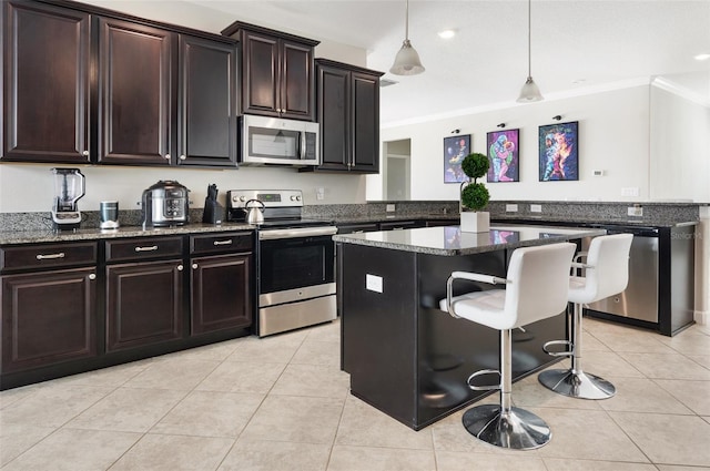 10008 Celtic Ash Dr, Ruskin, FL 33573 - kitchen featuring stainless steel appliances, crown molding, a kitchen breakfast bar, light tile patterned floors, and dark stone countertops