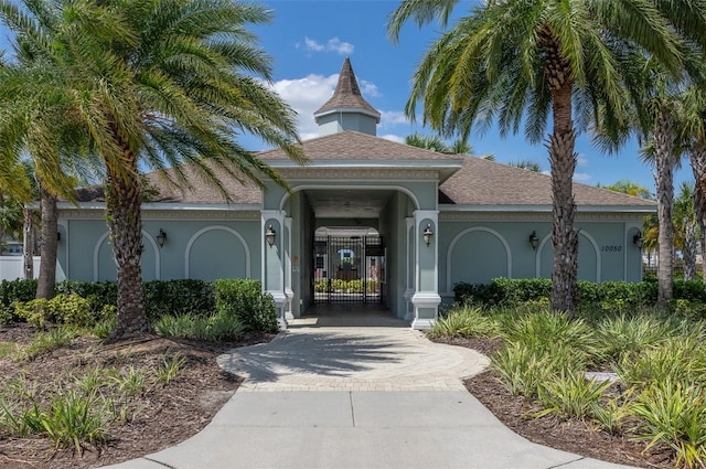 10008 Celtic Ash Dr, Ruskin, FL 33573 - entrance to property with stucco siding, a gate, decorative driveway, and a shingled roof