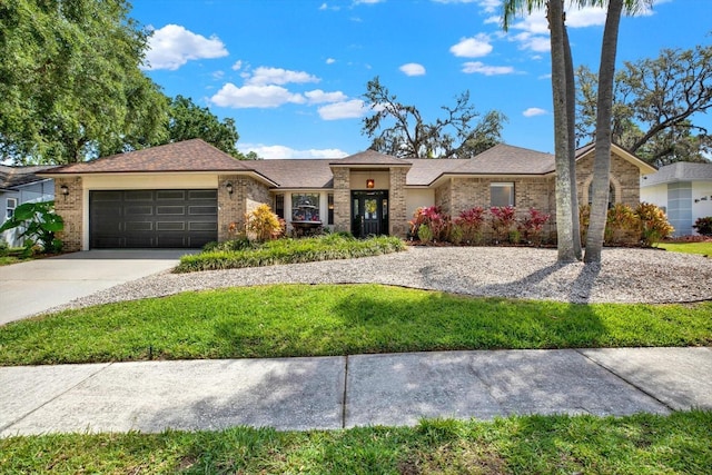 ranch-style house featuring an attached garage, concrete driveway, brick siding, and a front yard