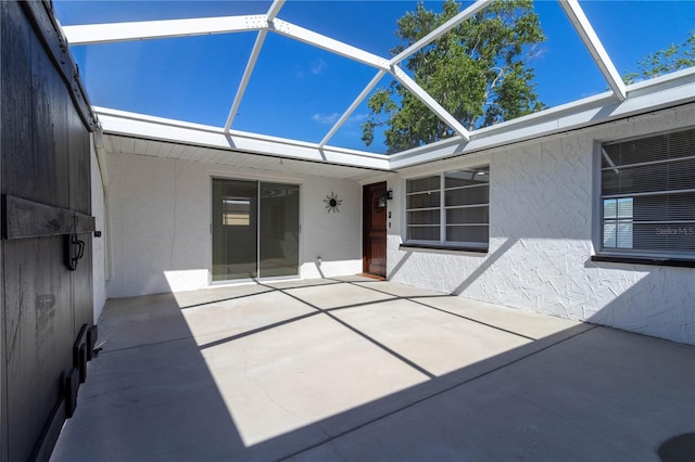 view of patio featuring glass enclosure