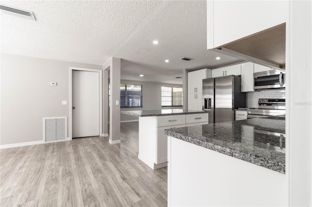 kitchen with white cabinetry, visible vents, and appliances with stainless steel finishes