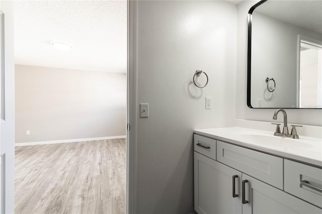 bathroom with vanity, baseboards, and wood finished floors