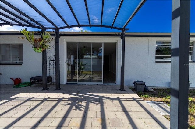 exterior space with a pergola, stucco siding, and a patio