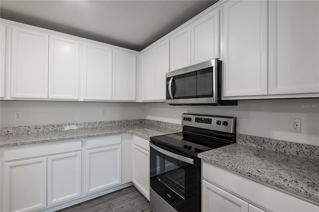 kitchen featuring white cabinetry, wood finished floors, and appliances with stainless steel finishes