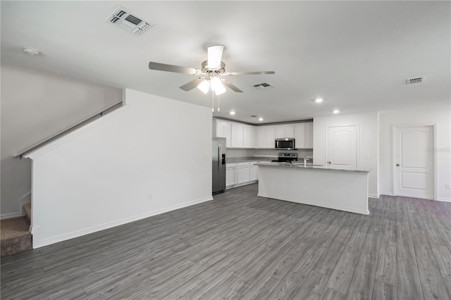 kitchen with a ceiling fan, wood finished floors, appliances with stainless steel finishes, open floor plan, and visible vents