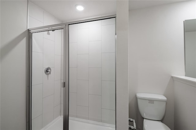 bathroom with a shower stall and toilet