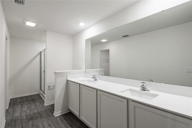 bathroom with a sink, a shower stall, and visible vents