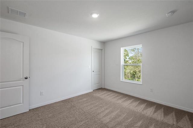 carpeted empty room with baseboards and visible vents