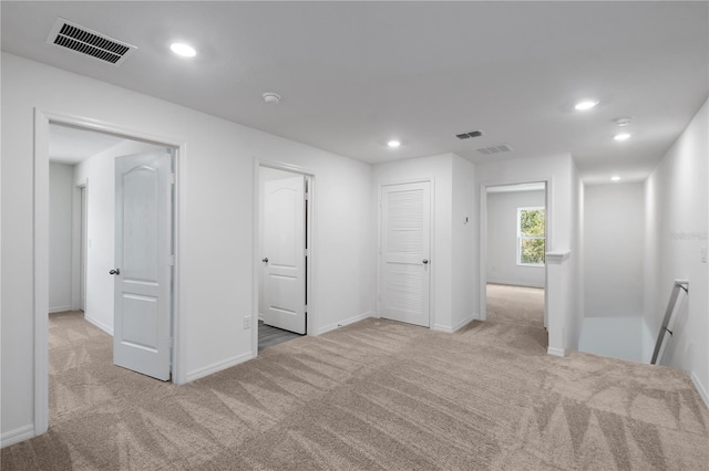 carpeted empty room featuring recessed lighting, baseboards, and visible vents