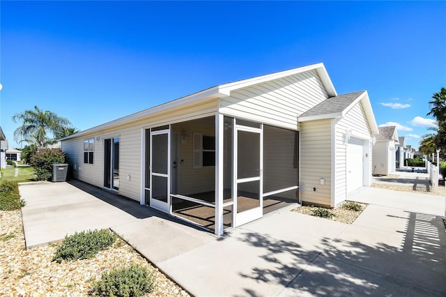 back of house featuring an attached garage and a sunroom