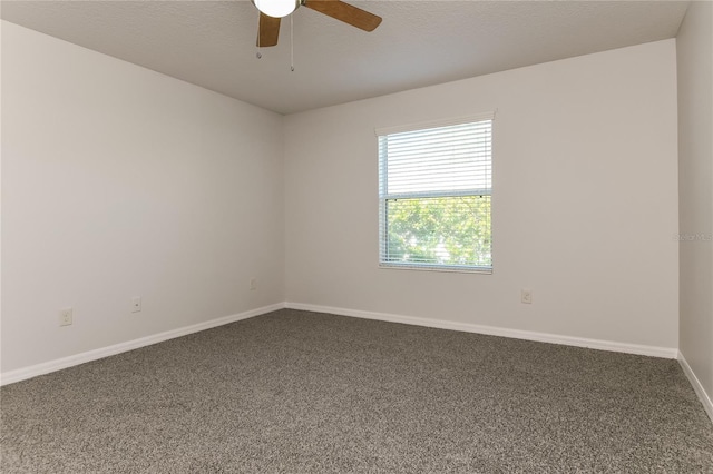 empty room featuring ceiling fan, baseboards, and dark colored carpet