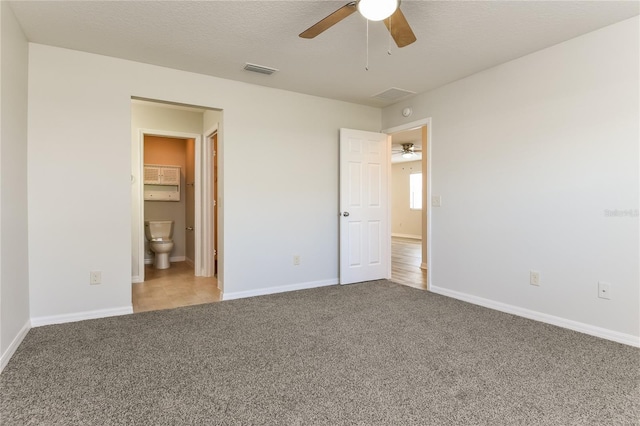 unfurnished bedroom featuring carpet floors, a ceiling fan, visible vents, and baseboards