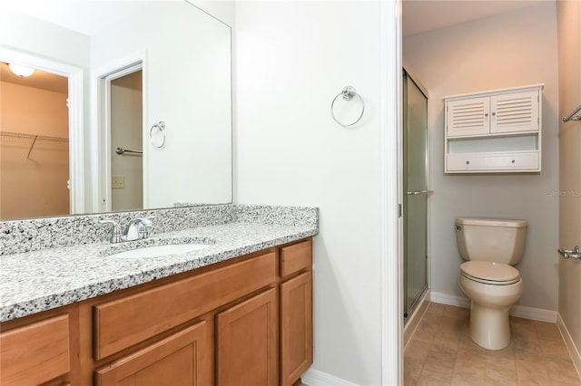 full bathroom with a shower stall, tile patterned floors, toilet, vanity, and baseboards