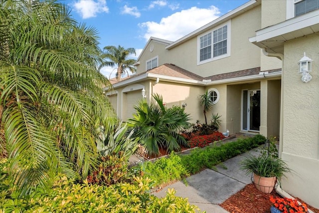 11260 Kapok Grand Cir, Madeira Beach, FL 33708 - entrance to property with an attached garage and stucco siding