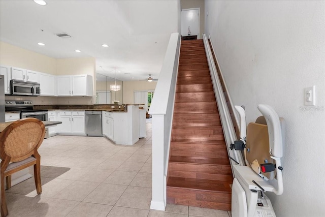 11260 Kapok Grand Cir, Madeira Beach, FL 33708 - stairway featuring tile patterned flooring, visible vents, and recessed lighting