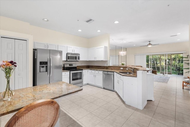 11260 Kapok Grand Cir, Madeira Beach, FL 33708 - kitchen featuring a peninsula, light tile patterned flooring, visible vents, stainless steel appliances, and a sink