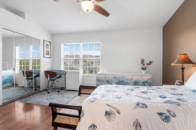 11260 Kapok Grand Cir, Madeira Beach, FL 33708 - bedroom featuring a textured ceiling, a closet, a ceiling fan, wood finished floors, and lofted ceiling