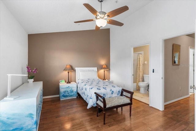11260 Kapok Grand Cir, Madeira Beach, FL 33708 - bedroom with baseboards, vaulted ceiling, ensuite bath, ceiling fan, and wood finished floors
