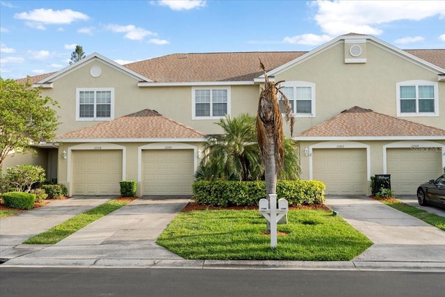11260 Kapok Grand Cir, Madeira Beach, FL 33708 - view of property featuring concrete driveway, a garage, and stucco siding