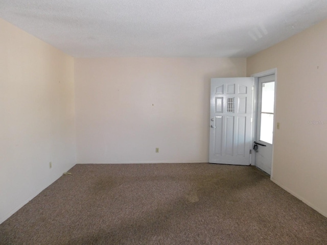 carpeted empty room featuring a textured ceiling