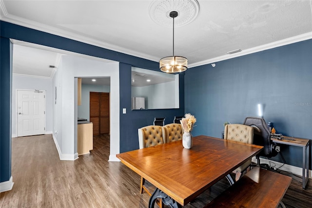 215 Central Ave Unit 4F, Saint Petersburg, FL 33701 - dining area with crown molding, wood finished floors, baseboards, and visible vents