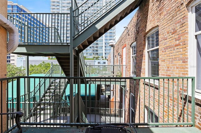 215 Central Ave Unit 4F, Saint Petersburg, FL 33701 - exterior space featuring a balcony, stairs, and brick siding