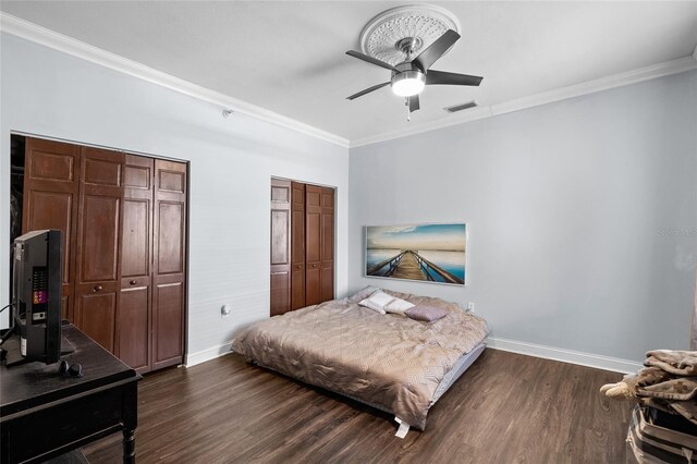 215 Central Ave Unit 4F, Saint Petersburg, FL 33701 - bedroom with two closets, ornamental molding, visible vents, baseboards, and dark wood-style floors